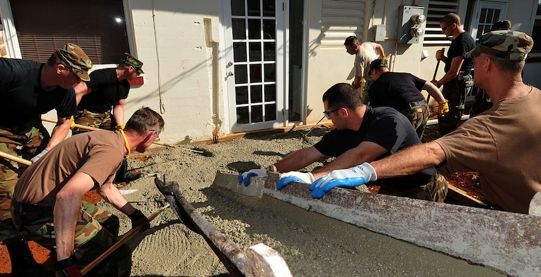 COAST GUARD AIR STATION BORINQUEN, Puerto Rico --  Members of the 176th Wing's Civil Engineer Squadron pour concrete for a patio here Feb. 11, 2010. A group of 45 squadron members spent two weeks here in early February to train and sharpen their skills on a wide range of infrastructure projects, upgrades and renovations. The squadron undertakes such a mission --  called a Deployment for Training, or DFT -- every year or two. Recent DFTs have taken the squadron's men and women to Israel, Southern California, Hawaii, Ecuador, Okinawa, Minnesota and Texas. AKANG photo by 1st. Lt. John Callahan. 