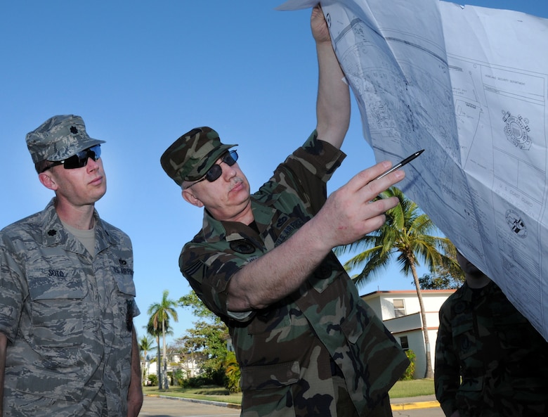 COAST GUARD AIR STATION BORINQUEN, Puerto Rico -- Holding a map to the air station, Chief Master Sgt. Roger Miller, the senior NCO of the Alaska Air National Guard's 176th Civil Engineer Squadron, points out project locations to Lt. Col. Ed Soto, the squadron's commander. A group of 45 squadron members spent two weeks here in early February to train and sharpen their skills on a wide range of infrastructure projects, upgrades and renovations. The squadron undertakes such a mission --  called a Deployment for Training, or DFT -- every year or two. Recent DFTs have taken the squadron's men and women to Israel, Southern California, Hawaii, Ecuador, Okinawa, Minnesota and Texas. AKANG photo by 1st. Lt. John Callahan. 