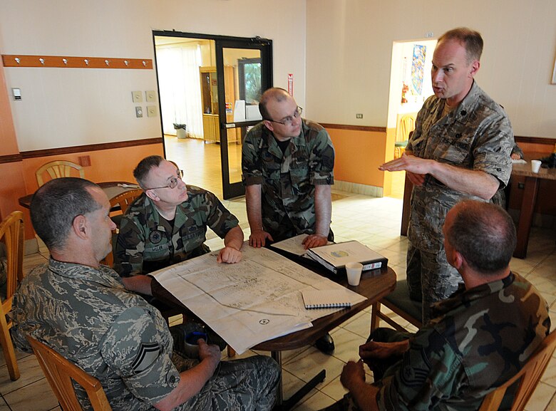 COAST GUARD AIR STATION BORINQUEN, Puerto Rico -- Lt. Col. Ed Soto (standing), commander of the Alaska Air National Guard's 176th Civil Engineer Squadron, outlines plans for the day at a morning meeting with his senior non-commissioned officers here Feb. 8, 2010. A group of 45 squadron members spent two weeks here in early February to train and sharpen their skills on a wide range of infrastructure projects, upgrades and renovations. The squadron undertakes such a mission --  called a Deployment for Training, or DFT -- every year or two. Recent DFTs have taken the squadron's men and women to Israel, Southern California, Hawaii, Ecuador, Okinawa, Minnesota and Texas. AKANG photo by 1st. Lt. John Callahan.