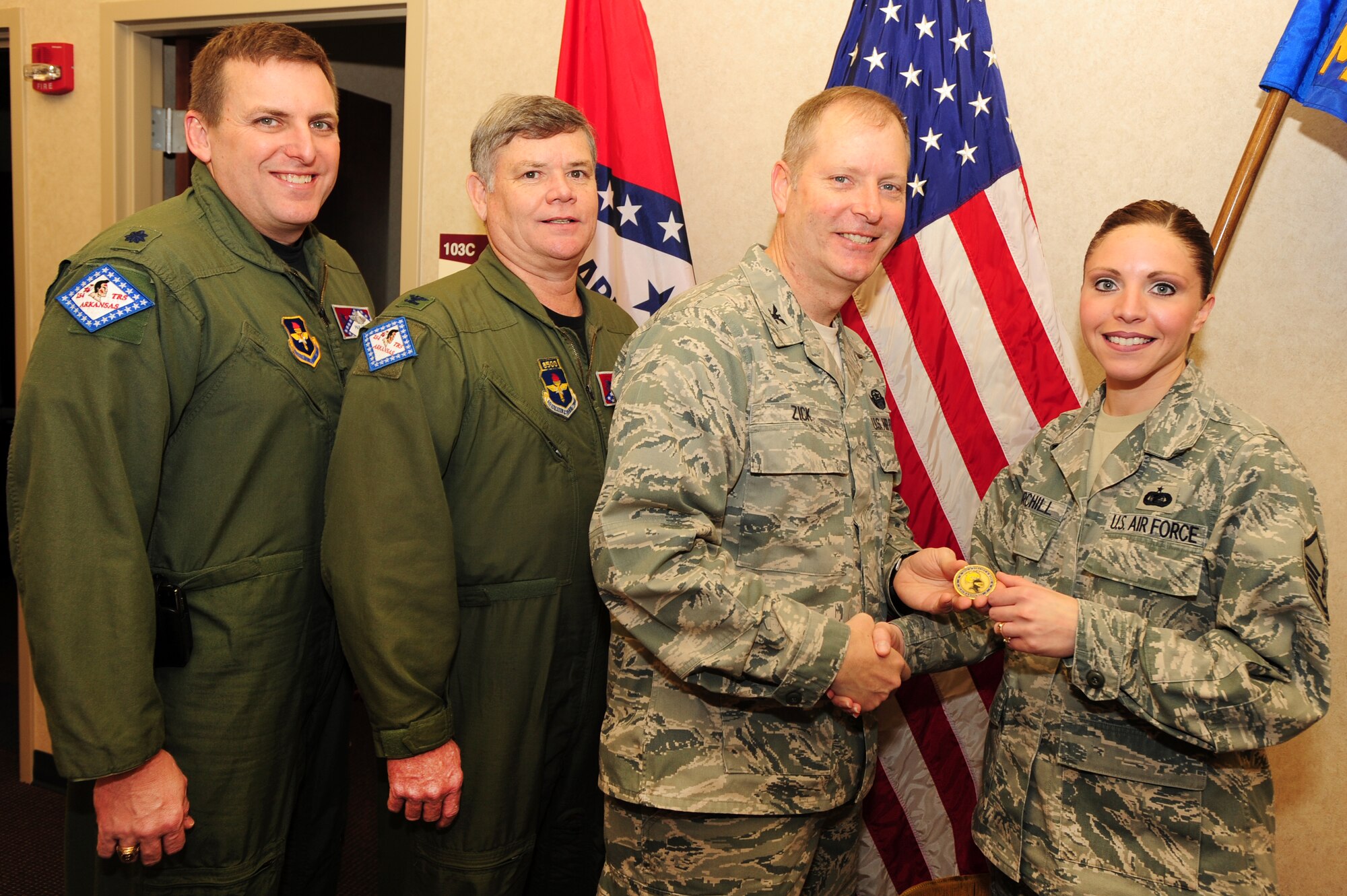 Col. Michael Zick, 19th Airlift Wing vice commander, Col. Jim Summers, 189th Airlift Wing commander, and Lt. Col. Paul Heye, 189th Airlift Wing vice commander, present Master Sgt. Jillian Churchill, 189th Mission Support Group knowledge operations manager, with a coin Feb. 24 for being the Combat Airlifter of the Week. (U.S. Air Force photo by Senior Airman Steele C. G. Britton)