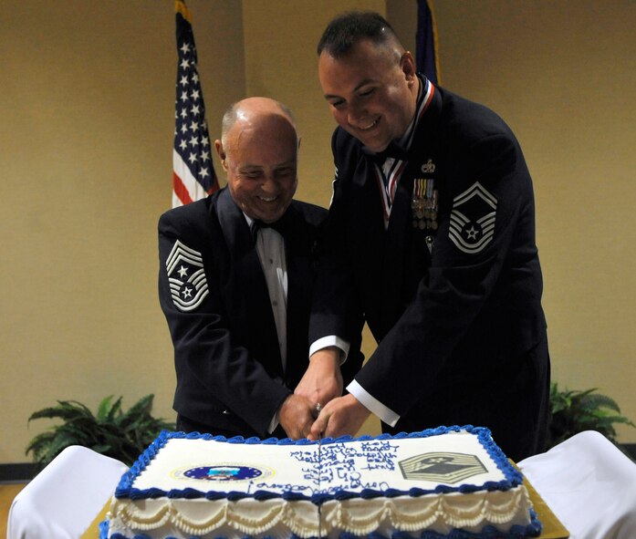 MOODY AIR FORCE BASE, Ga. -- Retired Chief Master Sgt. Earl Hendrix and Senior Master Sgt. Michael Burton, 23rd Equipment Maintenance Squadron armament flight chief, cut the cake during the Chief’s Recognition Ceremony here Feb. 20. One of the oldest military traditions gathers commanders, supervisors, friends and family for a special ceremony to recognize those selected for the highest enlisted rank within the Air Force. (U.S. Air Force photo by Staff Sgt. Schelli Jones)
