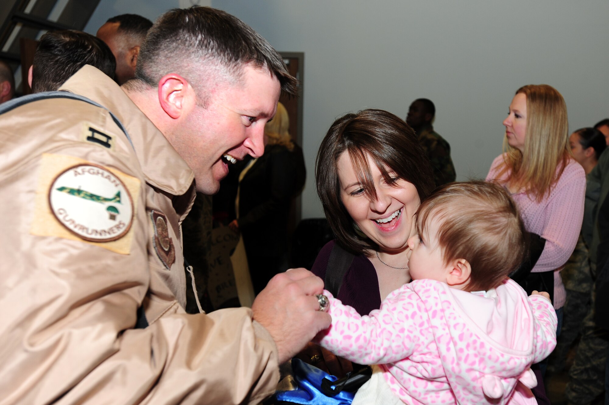 Capt. Coy Kinsey, 41st Airlift Squadron chief of tactics, greets his daughter, Audrey, and wife, Lisa, upon his return Feb. 23 from his deployment to Afghanistan. Capt. Kinsey and more than 150 Little Rock Airmen were welcomed home by loved ones from their deployment in support of operation Enduring Freedom. (U.S. Air Force photo by Senior Airman Steele C. G. Britton)