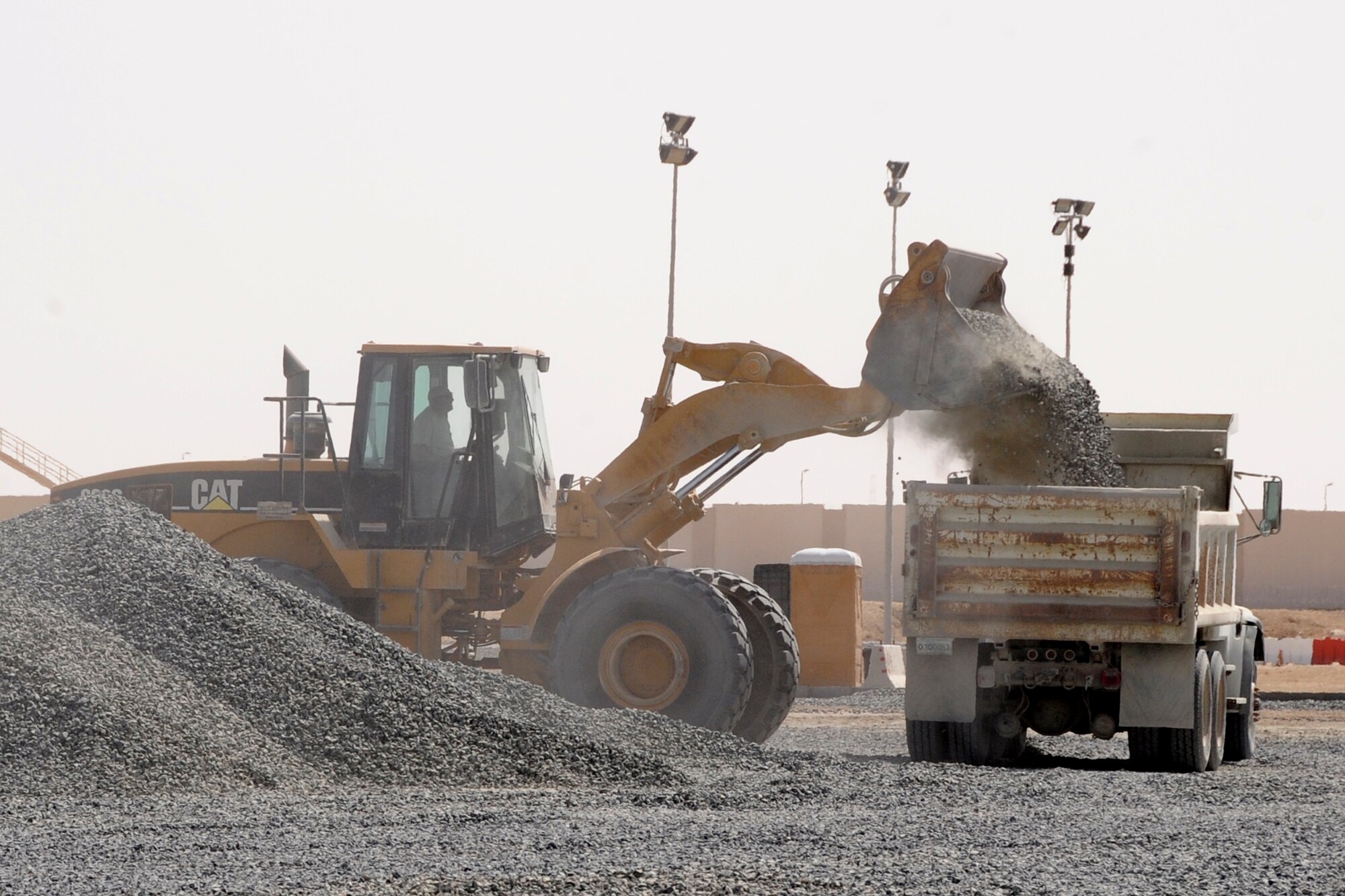 Members of the 380th Expeditionary Civil Engineer Squadron load rocks into a dump truck at a non-disclosed base in Southwest Asia on Feb. 24, 2010. The work was part of a resurfacing area for a parking area.  The 380th ECES is part of the 380th Air Expeditionary Wing. (U.S. Air Force Photo/Senior Airman Jenifer H. Calhoun/Released)
