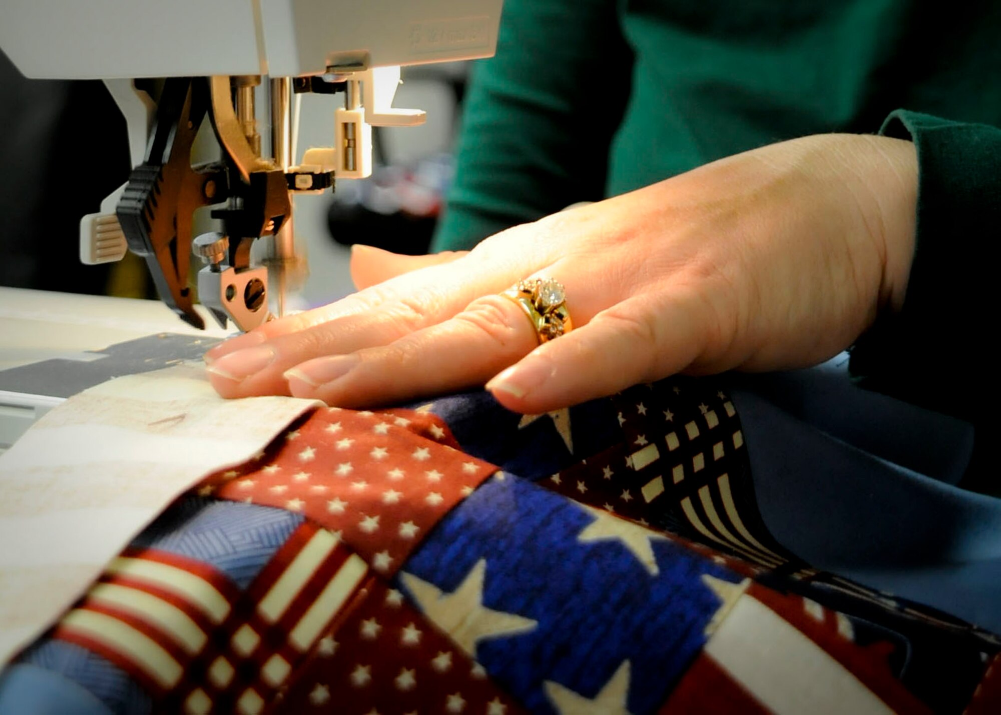 Leslie Scott stitches a border on a quilt top at the Airmen and Family Readiness Center at Cannon Air Force Base, N.M., Feb. 19. Cannon volunteers sends completed quilts to Operation Home Front Quilts and organization that has sent out approximately 1600 quilts to families who lost their son or daughter in war. (U.S. Air Force photo/ Senior Airman Cardenas)