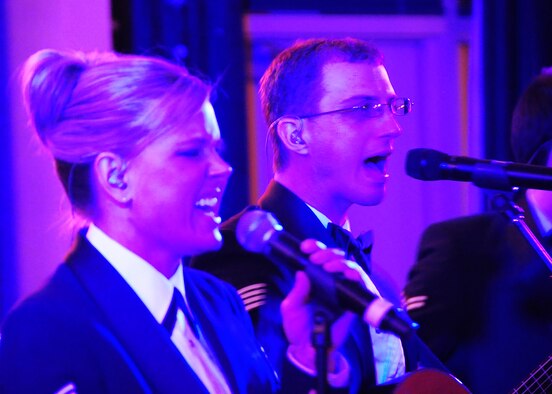 ELLSWORTH AIR FORCE BASE, S.D. -- (Left to right) Tech. Sgt. Lara Murdzia, NCO in charge and lead vocalist, and Staff Sgt. Clint Whitney, musical director and vocalist for the United States Air Force Heartland of America Band "Night Wing," sing "Play that Funky Music," originally performed by "Wild Cherry," during the 28th Bomb Wing Winter Formal, Feb. 20.  Night Wing has shared the stage with singers Neil McCoy, Jo Dee Messina, Jollie Edwards, Jessica Andrews and the Beach Boys among others. (U.S. Air Force photo/Airman 1st Class Anthony Sanchelli)