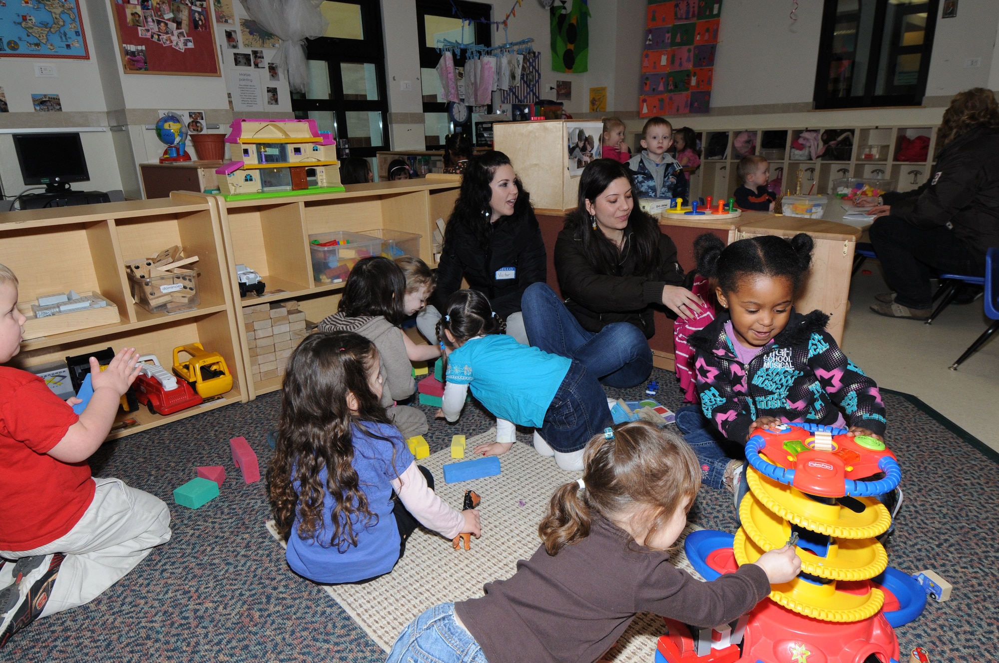 Two students from the Institute of Flora in Pordenone play with the children at the Child Development Center on Area F, during their visit to Aviano Air Base, Italy Feb. 18, 2010. The students are in their fifth year of high school and are studying to become social workers. (Air Force photo/Staff Sgt. MercedesKimble L. Crossland)