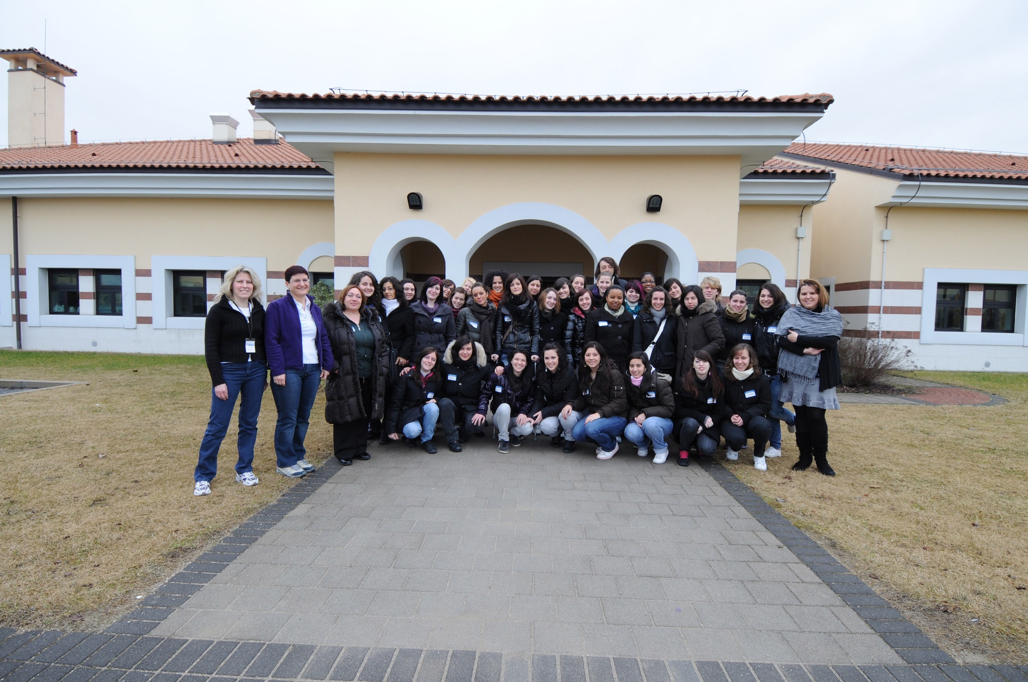 Child Development Center staff members and students from the Institute of Flora in Pordenone pose for a group photo during their visit to the CDC on Area F, Feb. 18, 2010. The 34 students are studying to become social workers. (Air Force photo/Staff Sgt. MercedesKimble L. Crossland)