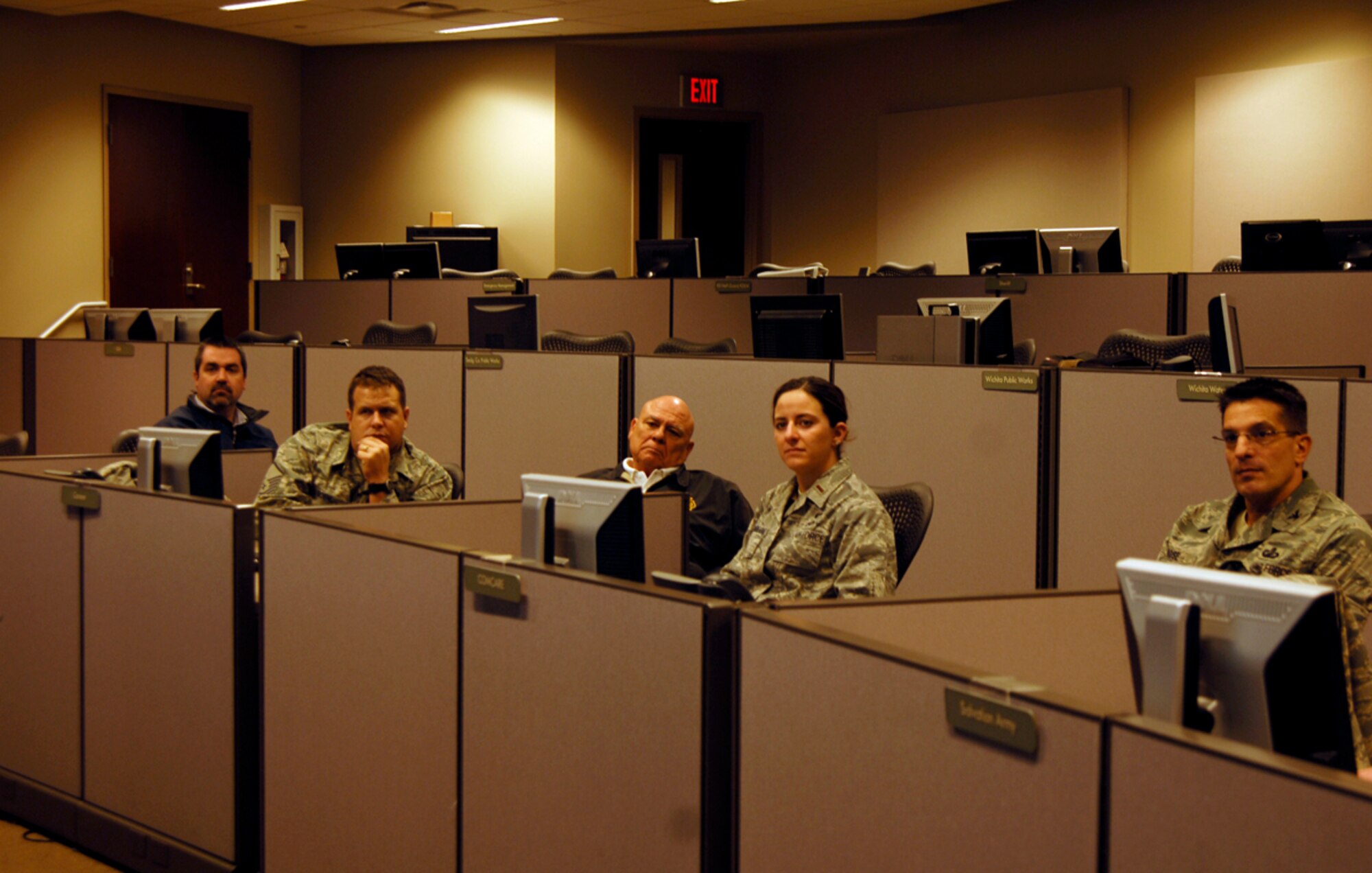 Team McConnell members listen as Sedgwick County Emergency Operation Center members describe the facility’s capabilities during a real-world emergency. The EOC, funded by Sedgwick county and maintained by county emergency management, provides McConnell, local frontline emergency responders and community leadership a central location to prepare for and withstand inclement weather, acts of terrorism and other various emergencies. (U.S. Air Force photo/ Senior Airman Abigail Klein)