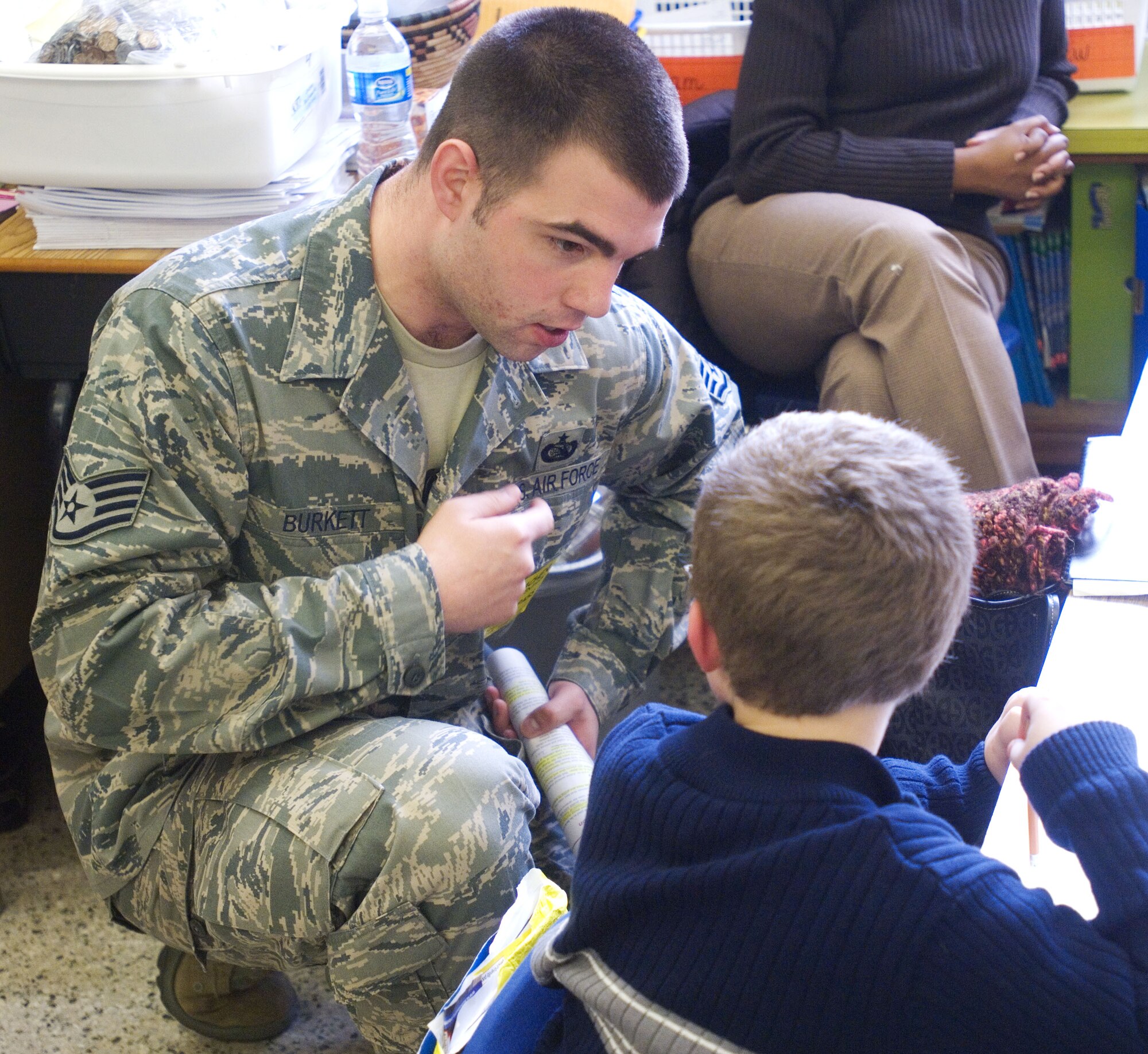 HAMPTON, Va. – Staff Sgt. Ryan Burkett, 83rd Communications Squadron Integrated Network Operations and Security Center Vulnerability Management technician, mentors students as part of a Junior Achievement program at Luther W. Machen Elementary School Feb. 23. Every week, Junior Achievement volunteers teach grade school students lessons in entrepreneurship, work readiness and financial literacy through hands-on programs.  (U.S. Air Force photo/Airman 1st Class Jason J. Brown)