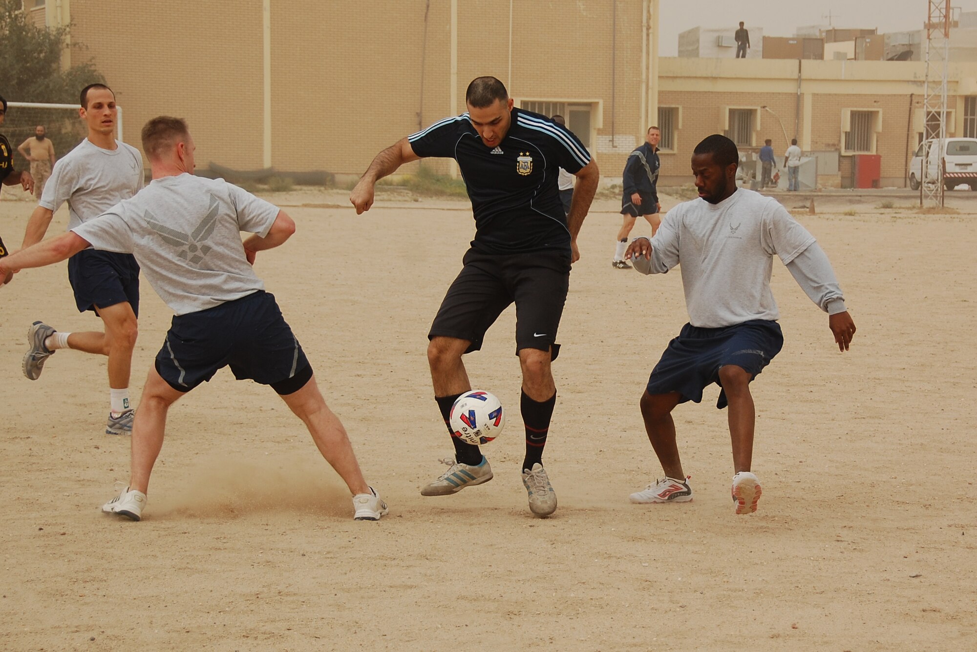U.S. Air Force Capt. Matthew Olson, left, and Staff Sgt. Jauron Myles, right, defend against a host nation Coalition member during a soccer scrimmage Feb. 24, 2010 at an air base in Southwest Asia. The 386th Air Expeditionary Wing’s team hopes to gain the championship title from the undefeated host nation team at a later date. (U.S. Air Force photo by Staff Sgt. Lindsey Maurice/Released)