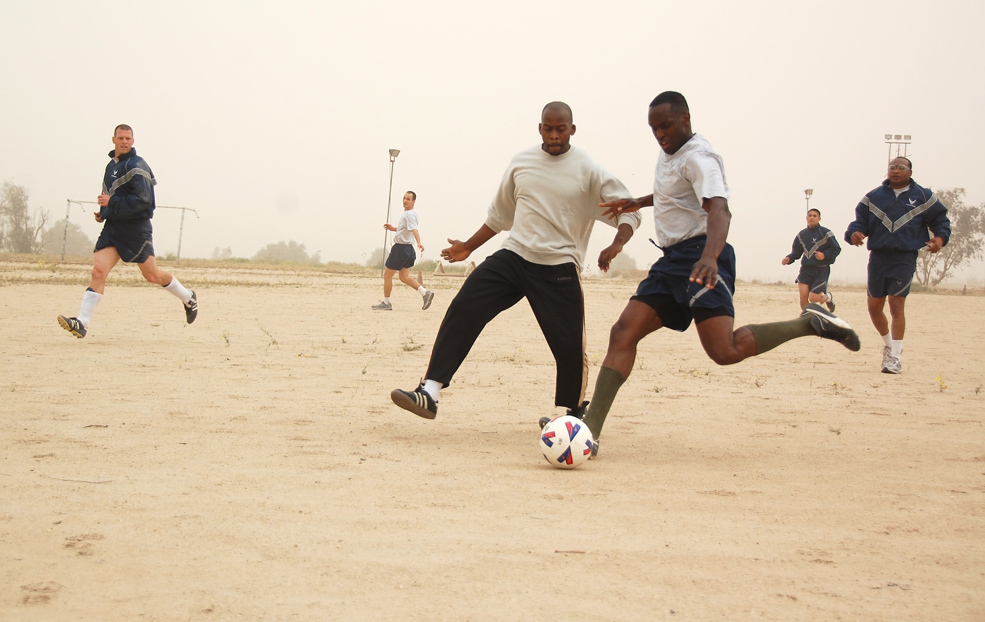 U.S. Air Force Staff Sgt. Chaderton Adams, right, fights for the ball against a host nation Coalition member during a soccer scrimmage Feb. 24, 2010 at an air base in Southwest Asia. The 386th Air Expeditionary Wing’s team hopes to claim the championship title from the undefeated host nation team at a later date. (U.S. Air Force photo by Staff Sgt. Lindsey Maurice/Released)