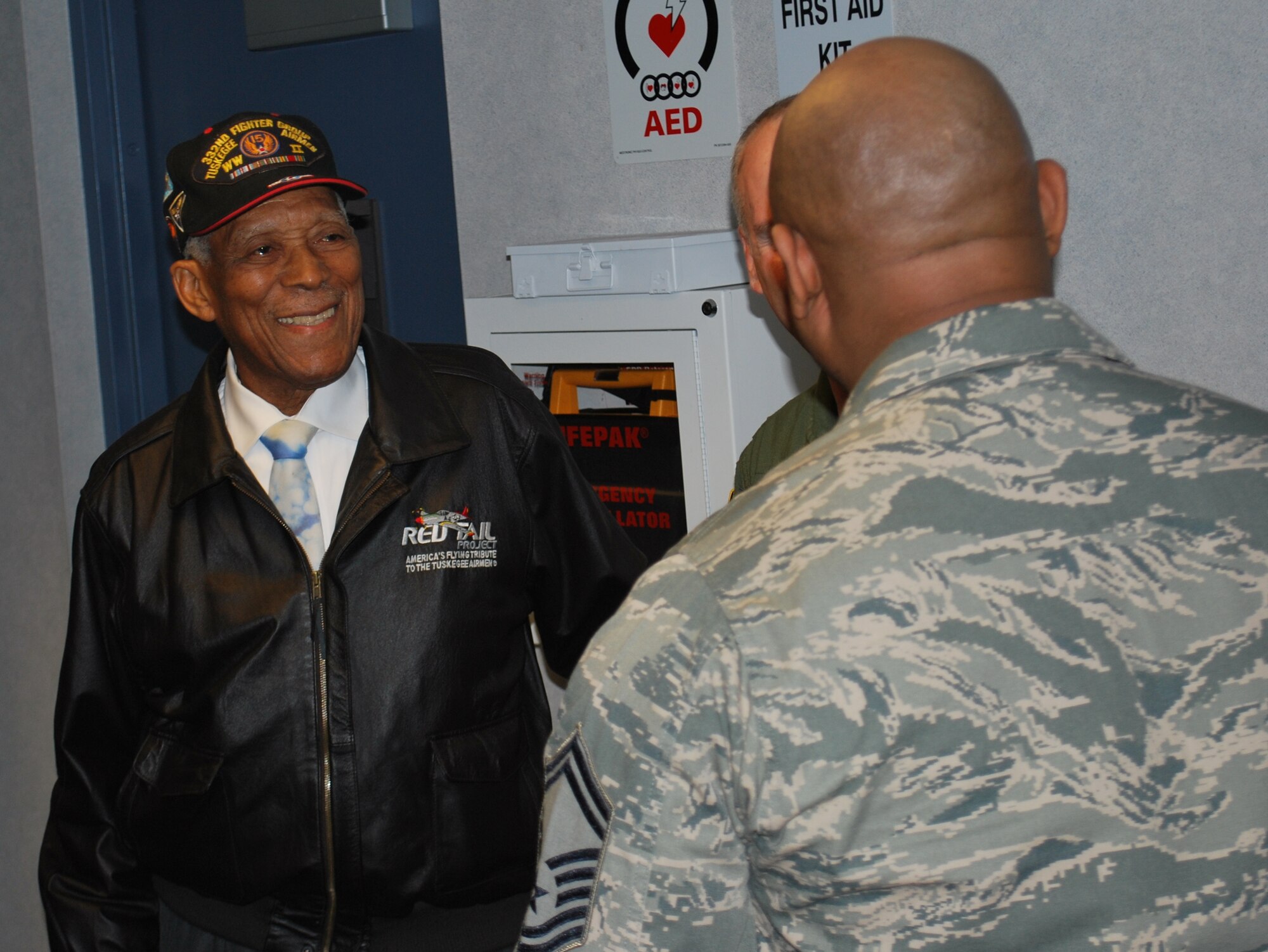 Retired Tech. Sgt. George Watkins, Sr. (left) a member of the Tuskegee Airmen, talks with Senior Master Sgt. Victor Dorsey on the 618th TACC's operations floor Feb. 23.  Mr. Watkins, who served in the military for 26 years as an aircraft and missile electrician, toured the 618th TACC to learn about current-day operations and met with Airmen to share his experiences in Air Force history.  (U.S. Air Force photo/Capt. Justin Brockhoff)