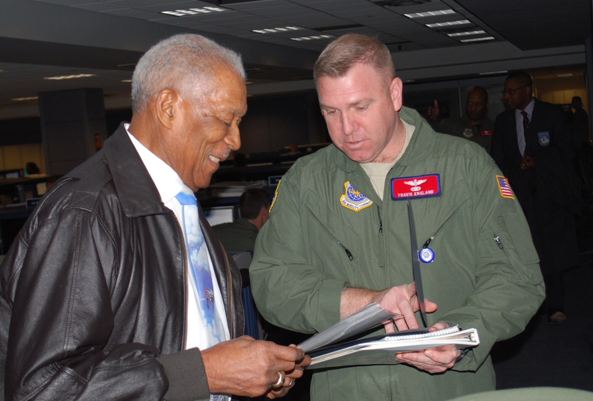 Retired Tech. Sgt. George Watkins, Sr. (left) a member of the Tuskegee Airmen, discusses the Air Mobility Command mission with Lt. Col. Travis England, 618th Tanker Airlift Control Center Command Section, on the 618th TACC's operations floor Feb. 23.  Mr. Watkins, who served in the military for 26 years as an aircraft and missile electrician, toured the 618th TACC to learn about current-day operations and met with Airmen to share his experiences in Air Force history.  (U.S. Air Force photo/Capt. Justin Brockhoff)