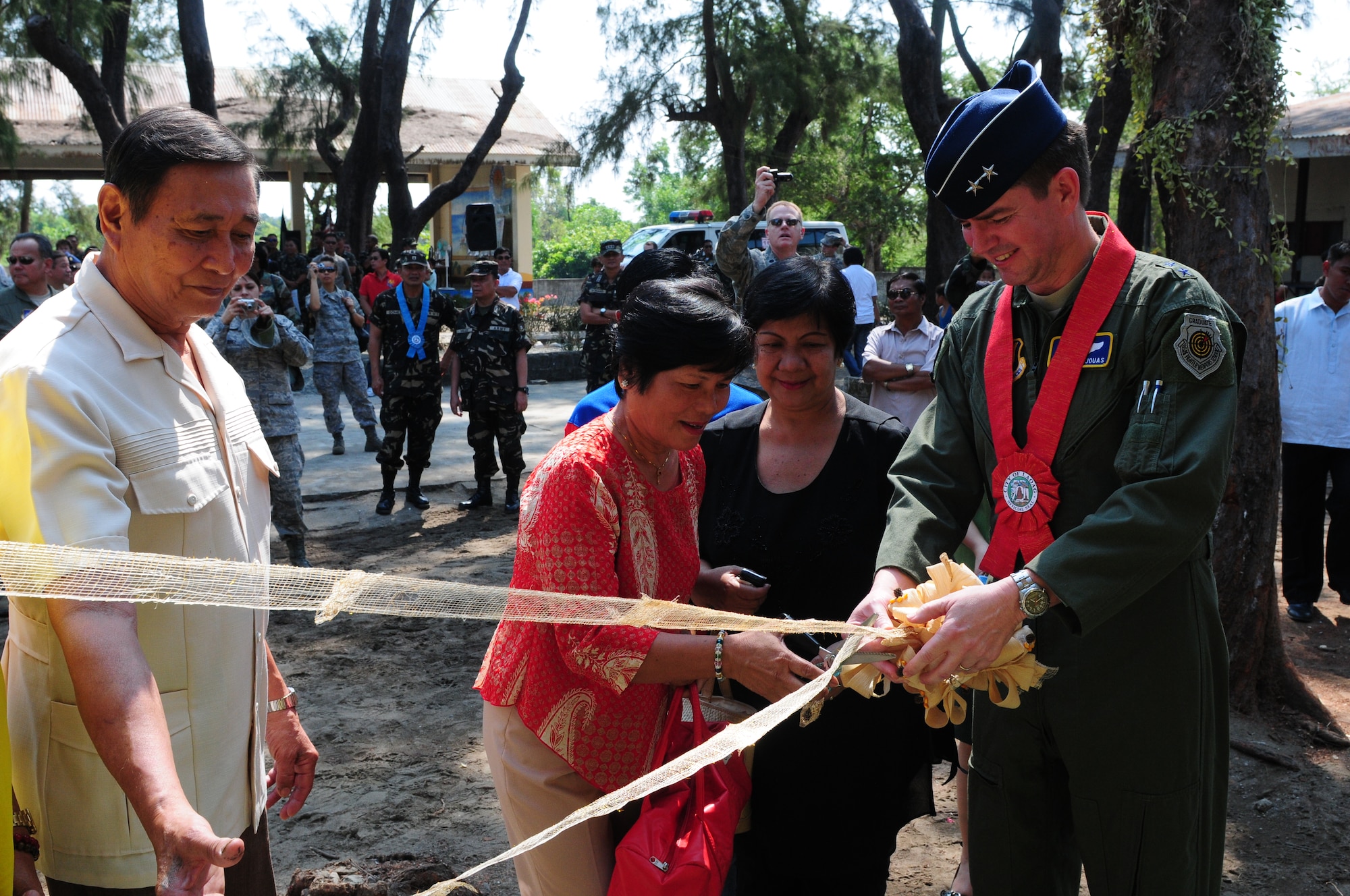 (from left to right) Mr. XXX, Ms. XXX, principal for Caaoacan Elementary School, and Maj. Gen. Jan-Marc Jouas, Director of Operations, Plans, Requirements and Programs at Pacific Air Forces, cut the ribbon on the newly rennovated classrooms at the school in Laoag, Philippines, Feb. 22. The 224th and the 554th Red Horse Squadron from Andersen Air Force Base, Guam provided support as part of a engineering civic assistance program for Operation Pacific Angel. Operation Pacific Angel is a joint and combined humanitarian assistance and civic assistance program conducted in the Pacific area of responsibility.   (U.S. Air Force photo/Capt. Genieve David)