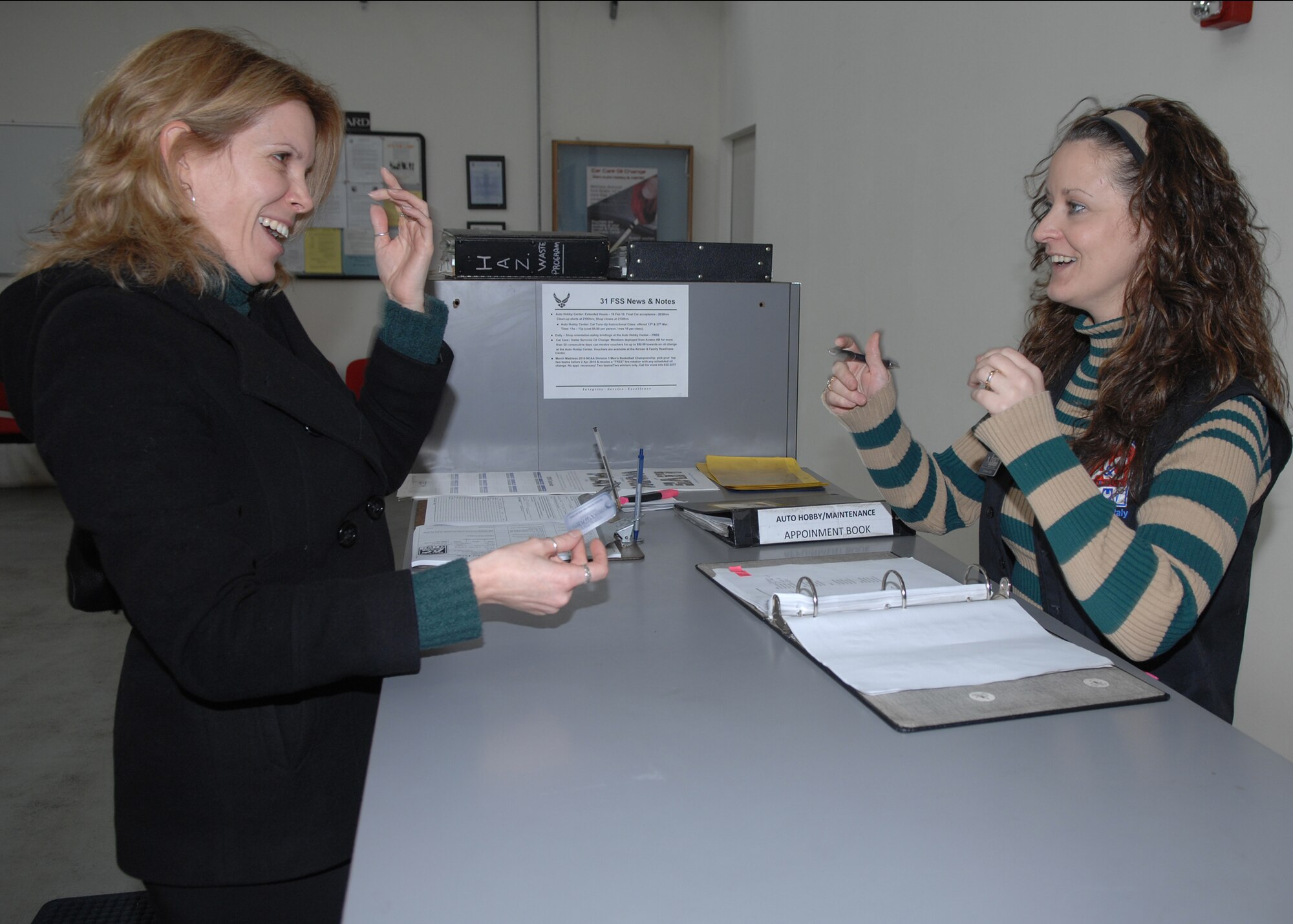 Mrs. Rachael Cossingham, 31st Force Support Squadron community readiness technician, gives her DePLAYment tag to Mrs. Christine Cogley, 31st Force Support Squadron, for a free oil change at the Auto Hobby Shop. The DePLAYment tags can be used at most force support facilities. (U.S. Air Force photo/Senior Airman Taylor Marr)
