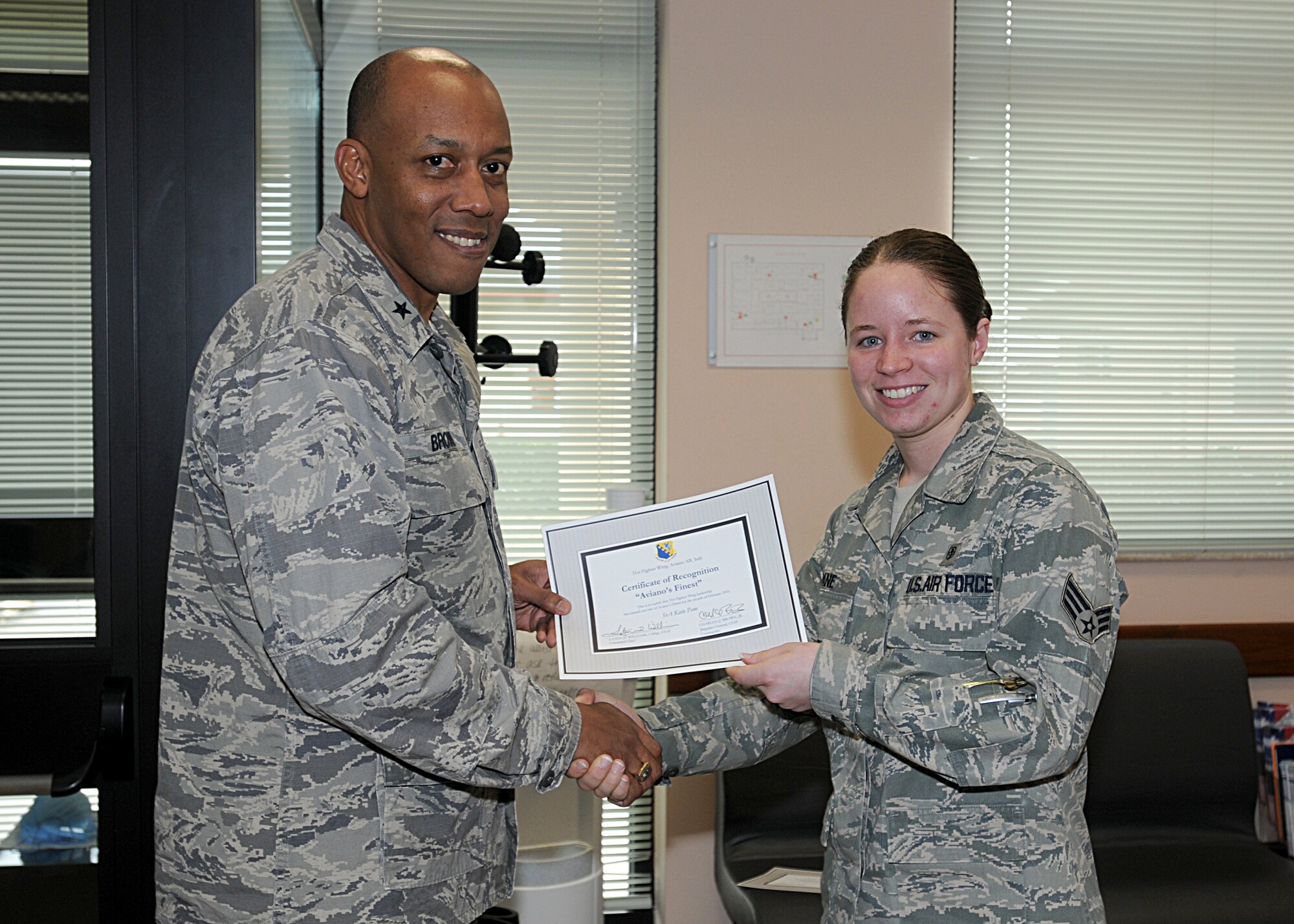 Brig. Gen. C.Q. Brown Jr., 31st Fighter Wing commander, congratulates Senior Airman Katie Pane, 31st Aerospace Medicine Squadron, on her selection as one of Aviano's Finest.  (U.S. Air Force photo/Senior Airman Tabitha M. Mans)