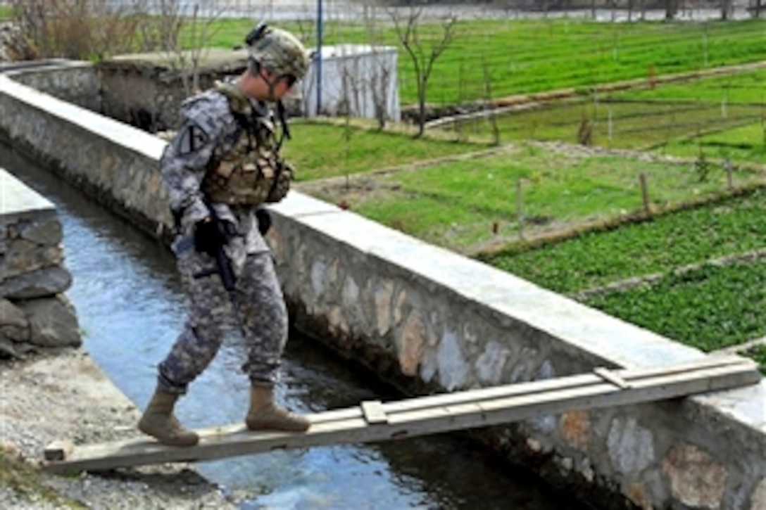 U.S. Army 1st Lt. Gabriel C. Dearman carefully crosses a canal in Tantil village in the Manogai District of eastern Kunar province, Afghanistan, Feb. 21, 2010. Dearman is a platoon leader assigned to Company D, 2nd Battalion, 12th Infantry Regiment, Task Force Lethal. 