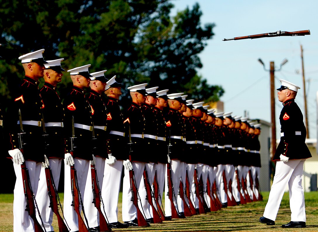 Lance Cpl. Nicholas Meekins, a rifle inspector with the United States Marine Silent Drill Platoon, tosses a rifle over his back to Lance Cpl. Chase Pinkerman during a performance aboard Marine Corps Air Station Yuma in Yuma, Ariz. Meekins is a three year member of the platoon. (Photo by Cpl. Bobby J. Yarbrough)