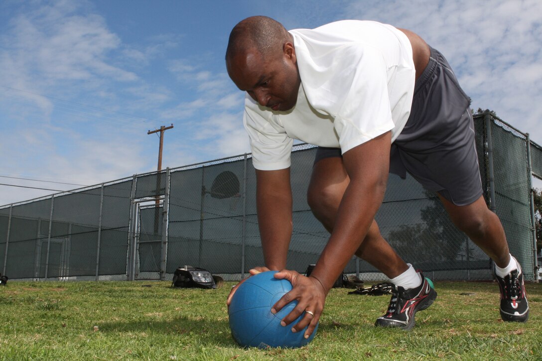 Gunnery Sgt. Mark Rivers, the administrative chief for Marine Medium Tiltrotor Squadron 161, uses a medicine ball to balance himself whlie doing mountain climbers during the Ultimate Warrior Challange, Feb. 24. The workout is designed to increase heart rate to burn additional calories in a one-hour span.