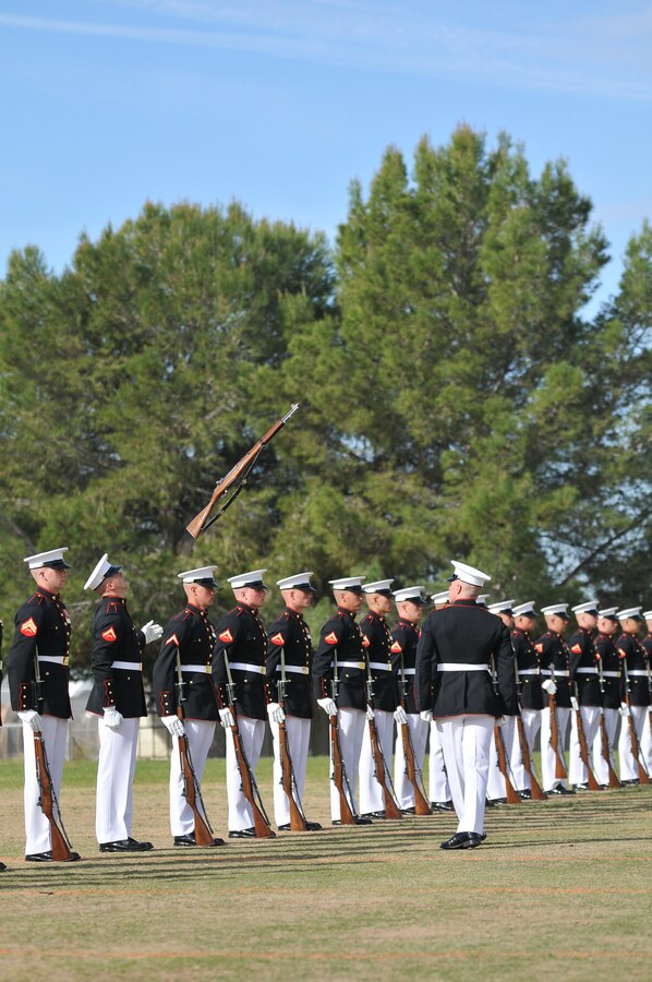 Lance Cpl. Nicholas Meekins, right, Silent Drill Platoon rifle inspector, tosses an M-1 Garand rifle back to Lance Cpl. Chase Pinkerman during a dress rehearsal at the Marine Corps Air Station in Yuma, Ariz., on Feb. 24, 2010. The Marine Corps Battle Color Detachment, made up of the platoon, as well as the Marine Corps Drum and Bugle Corps and the Marine Corps Color Guard, kicked off its annual spring tour in Yuma on Feb. 26-27 with performances on the air station and at two local high schools. Based in Washington, D.C., the Marines spend several weeks rehearsing in Yuma's mild winter each year before touring.