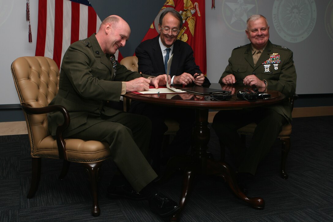 (From left to right) Maj. Gen. Carl B. Jensen, commander of Marine Corps Installations East, Erskine Bowles, the president of University of North Carolina, and Maj. Gen. Paul E. Lefebvre, the commander of U.S. Marine Corps Forces, Special Operations Command, sign two memorandums, which will form a lasting bond between the organizations Feb. 24, at the MARSOC headquarters building auditorium. The memorandums signify a collaborative agreement between three organizations.