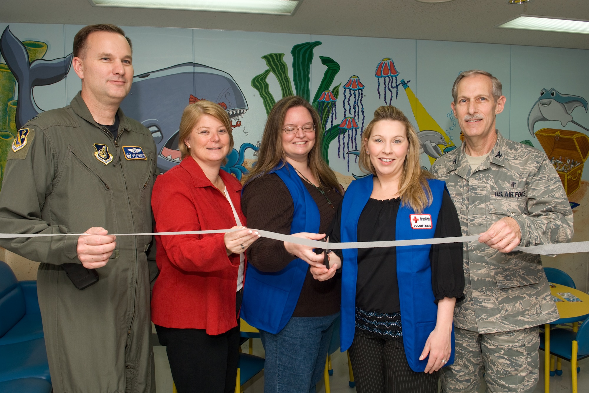 YOKOTA AIR BASE, Japan -- (from left to right) Col. Timothy Robinette, 374th Medical Group commander, Mrs. Mary Basiliere, Yokota Air Base American Red Cross Senior Station Manager, Mrs. Kelley Monkevich, American Red Cross volunteer, Mrs. Angela Rainey, American Red Cross volunteer, and Col. Thomas Grimm, 374th Dental Squadron commander, prepare to cut a ribbon signifying the opening the Dental Clinic Children's waiting room re-design as part of the Military Hospital Outreach Program funded by the American Red Cross, here, Feb. 26. (U.S. Air Force photo/Osakabe Yasuo)