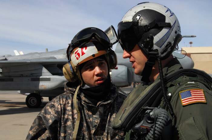 NELLIS AIR FORCE BASE, Nev. -- Petty Officer3rd Class, aviation structural mechanic Bryan Shishido, talks with Lt. Nick George, a EA-6B(Prowler) pilot, from Tactical Electronic Warfare Squadron  One Three Nine (VAQ-139) from Whidbey Island, Wash. before stepping to his aircraft at Red Flag 10-3 Feb. 23, 2010.  Red Flag is a realistic combat training exercise involving the air forces of the United States and its allies. The exercise is conducted on the 15,000-square-mile Nevada Test and Training Range, north of Las Vegas.  (U.S. Air Force Photo by Staff Sgt. William P. Coleman/RELEASED)