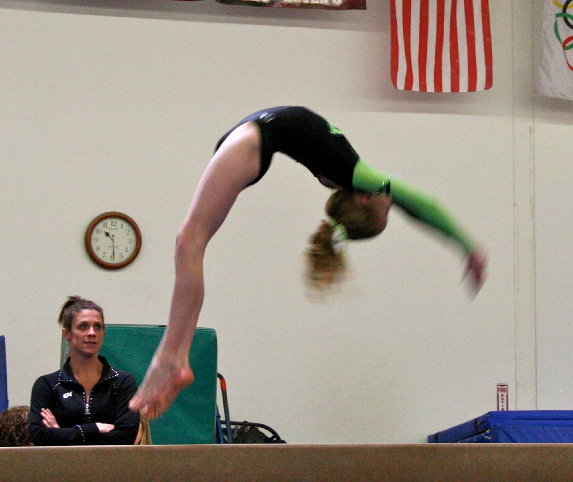 CAMARILLO, Calif. --  Ashley Castellenos, age 13, performs on balance beam at the Snowflake Classic gymnastics competition here Feb. 7 as Coach Allison Pledger watches. Castellenos is with the Vandenberg Youth Programs Jets girls gymnastics Level 7 team. (Photo by Cheryl Castellenos)