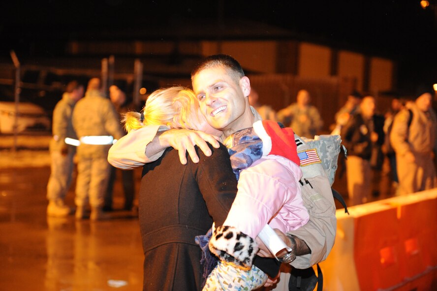 DYESS AIR FORCE BASE, Texas -- Capt. Elia Narayan, 317th Airlift Group, embraces his wife Emily and his daughter Devi. Captain Narayan was deployed to Southwest Asia for four months in support of Overseas Contingencies Operation. (U.S Air Force photo by Airman 1st Class Shannon Hall)