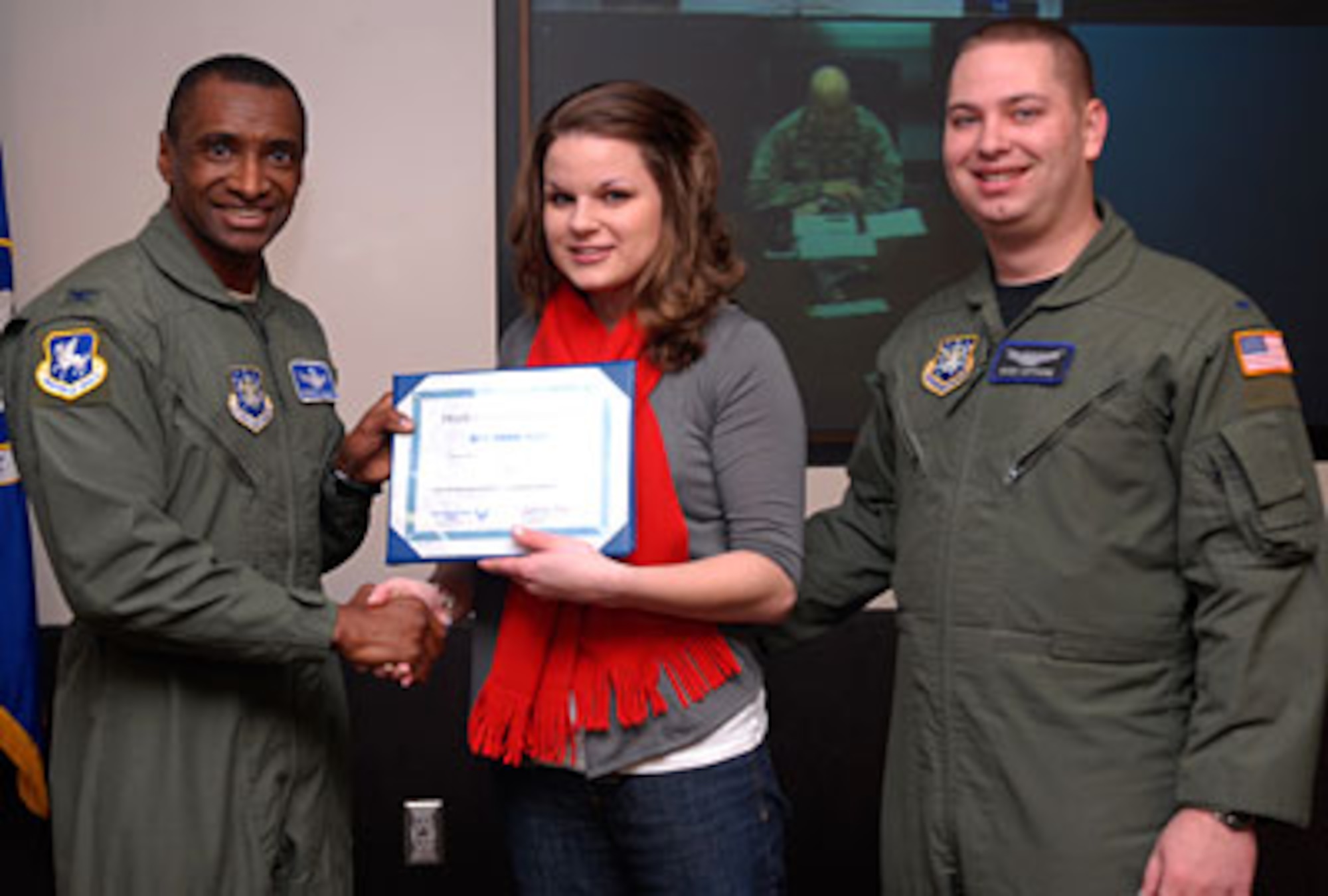 SCHRIEVER AIR FORCE BASE, Colo. - Col. Kenneth Allison presents Erin Wetmore with a certificate following a surprise announcement in which Mrs. Wetmore was announced as the winner of the Year of the Air Force Family "My Air Force Life" short story contest Feb. 24. Mrs. Wetmore was joined by her husband, 1st. Lt. Ross Wetmore, 50th Operations Support Squadron. (U.S. Air Force photo/Tech. Sgt. Stacy Foster)