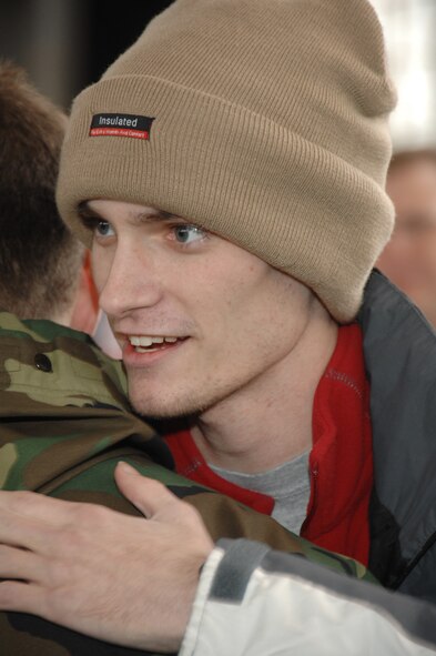 Senior Airman Tre Porfirio hugs a fellow 88th Communications Squadron “combat nerd” Feb. 18, 2010 at Wright-Patterson Air Force Base, Ohio.  About 300 Airmen, civilian employees and members of neighboring communities were on hand to welcome Porfirio home following his ground-breaking islet cell transplant surgery and 3-month recovery at Walter Reed Army Medical Center.  He was shot in the back by an insurgent Nov. 21, 2009 while deployed with an Army unit in a remote part of Afghanistan.  Airman Porfirio is a communications technician with the 88th Communications Squadron. (U.S. Air Force photo/Ben Strasser)
