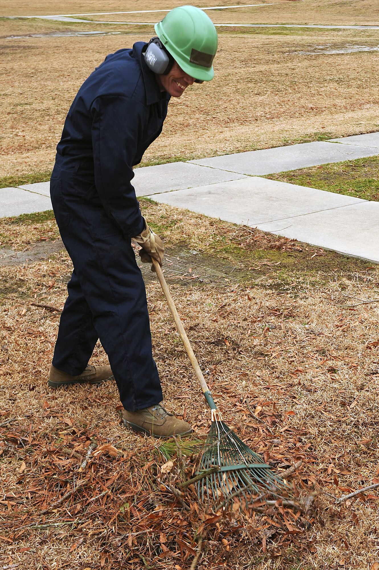 Tech Sgt. Douglas Gunn, 567th RED HORSE Squadron heavy equipment operator, rakes brush and leaves on Seymour Johnson Air Force Base, N.C., Feb. 24, 2010. After pushing large tree limbs through a wood chipper the remaining brush and leaves are raked together into smaller piles for disposal. Gunn hails from Greenville, N.C. (U.S. Air Force photo/Senior Airman Ciara Wymbs) 