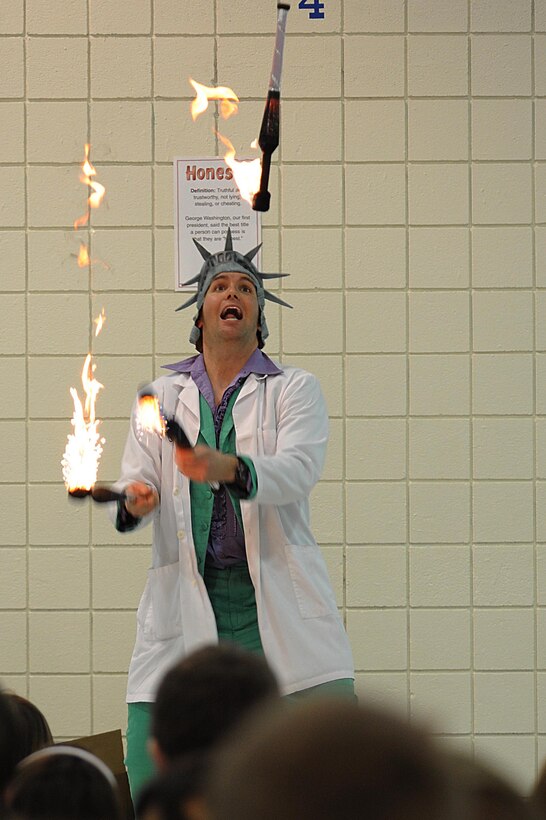 Capt. Bradley Harrelson, 28th Medical Operations Squadron dentist, also known as Dr. Juggles, juggles flaming torches at Francis Case School, Box Elder, S.D., Feb. 17. Dr. Juggles visited several local schools to promote National Children's Dental health month, which is observed every February according to the American Dental Association. (U.S. Air Force photo/Airman 1st Class Corey Hook)