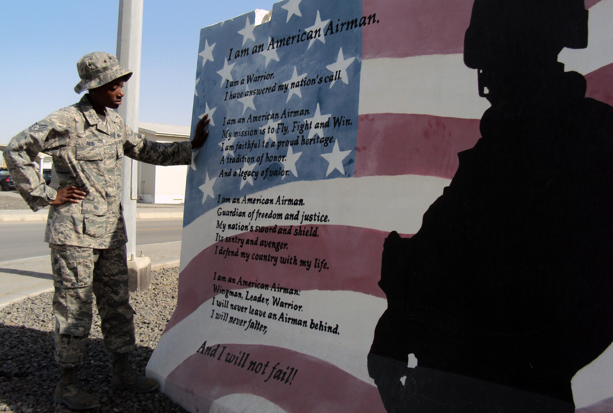 Staff Sgt. Sparkle Reid, a services journeyman, is deployed as the non-appropriated funds custodian for the 380th Expeditionary Force Support Squadron at a non-disclosed base in Southwest Asia.  Here, she is pictured looking at a painted mural of the Airman's Creed by the 380th Air Expeditionary Wing headquarters on Feb. 25, 2010. Sergeant Reed lost her uncle, Louie A. Williams, when the World Trade Center towers came down on Sept. 11, 2001. He worked on the 66th floor of the North Tower for the New York Port Authority as a paralegal. On Feb. 27, 2009, Sergeant Reid lost her father, Charles T. Reid, after complications from surgery. She credits both her uncle and her father as her inspiration for serving. Sergeant Reid is deployed from from the 48th Force Support Squadron at RAF Lakenheath, England, and her hometown is Queens, N.Y. (U.S. Air Force Photo/Master Sgt. Scott T. Sturkol/Released)