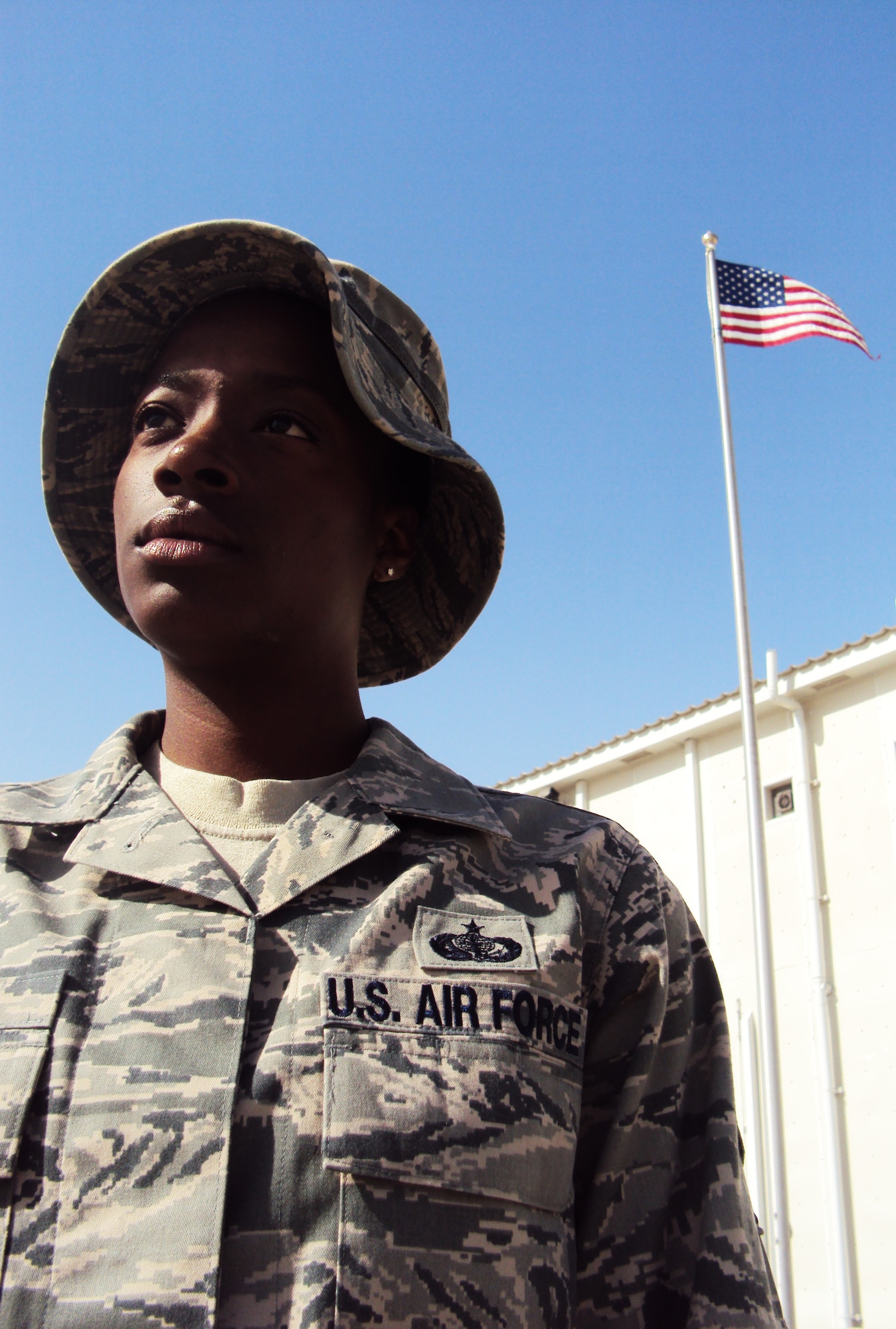 Staff Sgt. Sparkle Reid, a services journeyman, is deployed as the non-appropriated funds custodian for the 380th Expeditionary Force Support Squadron at a non-disclosed base in Southwest Asia.  Here she is pictured by the American flag by the 380th Air Expeditionary Wing headquarters on Feb. 25, 2010. Sergeant Reed lost her uncle, Louie A. Williams, when the World Trade Center towers came down on Sept. 11, 2001. He worked on the 66th floor of the North Tower for the New York Port Authority as a paralegal. On Feb. 27, 2009, Sergeant Reid lost her father, Charles T. Reid, after complications from surgery. She credits both her uncle and her father as her inspiration for serving. Sergeant Reid is deployed from from the 48th Force Support Squadron at RAF Lakenheath, England, and her hometown is Queens, N.Y. (U.S. Air Force Photo/Master Sgt. Scott T. Sturkol/Released)