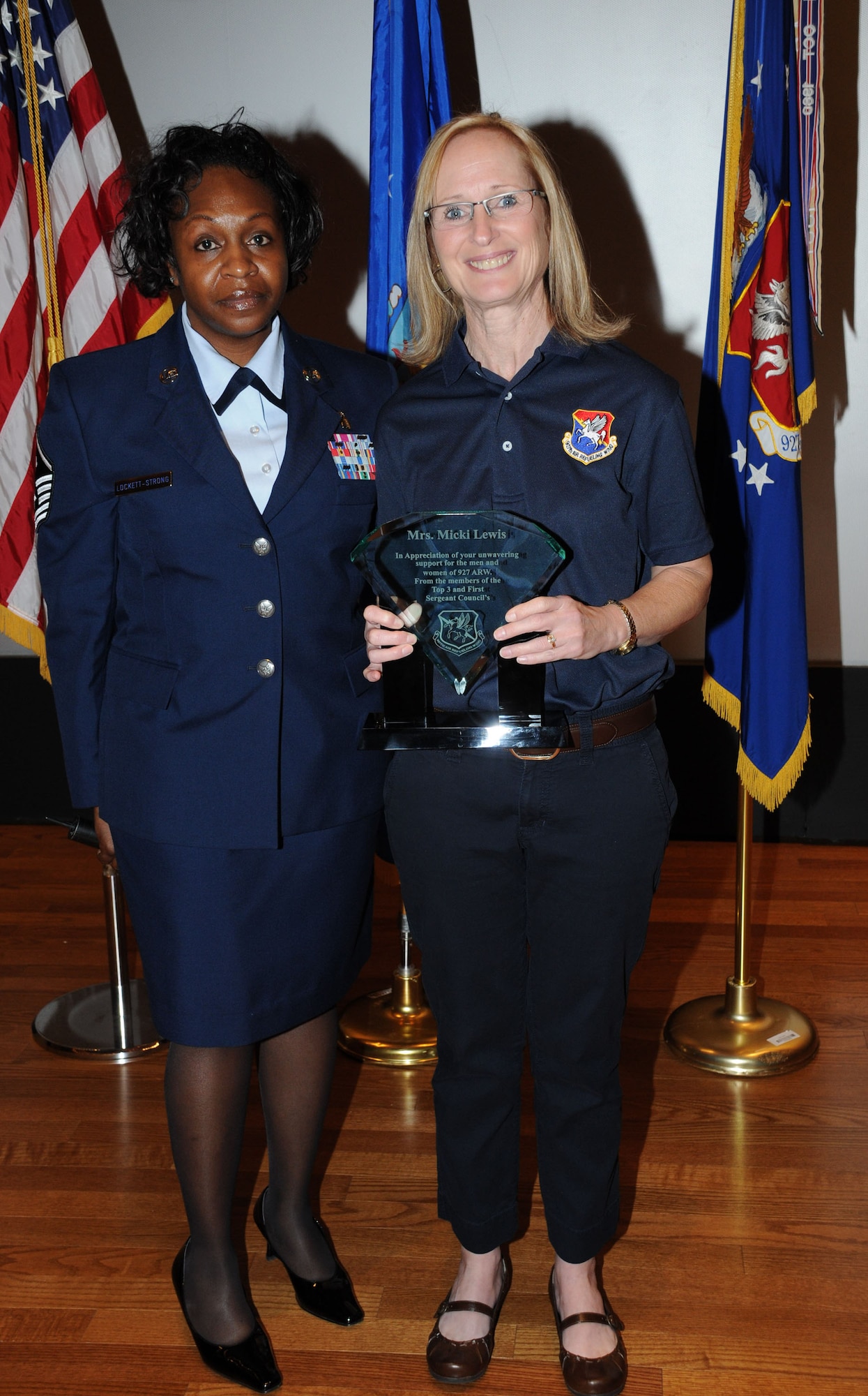 Mikki Lewis, wife of Col. Kenneth D. Lewis Jr., 927th Air Refueling Wing commander, receives an award at the quarterly commander's call Feb. 21 for her help and outstanding support for various wing activites.  (U.S. Air Force photo/Tech. Sgt. Denise Hauser)