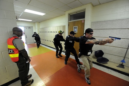 Darrion Holiwell observes as Charleston county aviation authority police prepare to start a hallway clearing exercise during the Active Shooter Training Course at Mt. Pleasant, S.C., Feb. 23, 2010. The AST course prepares first responders on how to react to a hostile situation. Mr. Holiwell is an instructor with AST. (U.S. Air Force photo by James M. Bowman/released)



