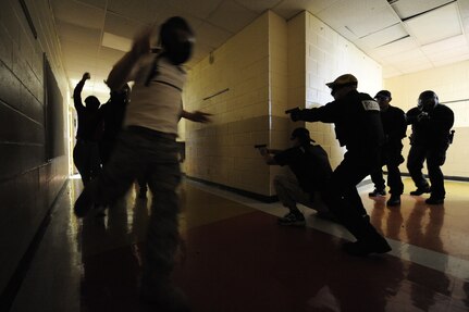 Mock hostages run by as Charleston county aviation authority police prepare to shoot an aggressor during the Active Shooter Training Course at Mt. Pleasant, S.C., Feb. 23, 2010. The AST course prepares first responders on how to react to a hostile situation. (U.S. Air Force photo by James M. Bowman/released)