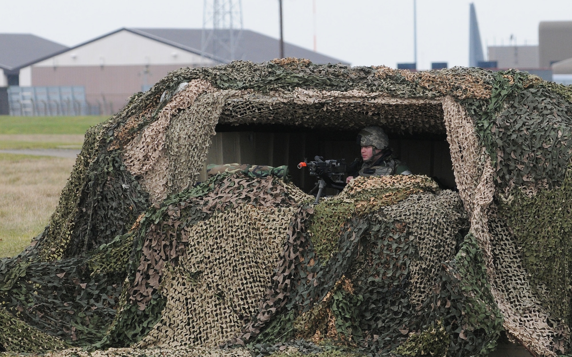 RAF MILDENHALL, England -- Amn. Kyle Butters, 100th Security Forces Squadron, mans a defensive fighting position minutes before a simulated chemical warfare attack during an operational readiness exercise Feb. 25. The outpost provides overwatch for the entry control point of Base X here throughout the second phase of the exercise. (U.S. Air Force photo/Senior Airman Thomas Trower) 