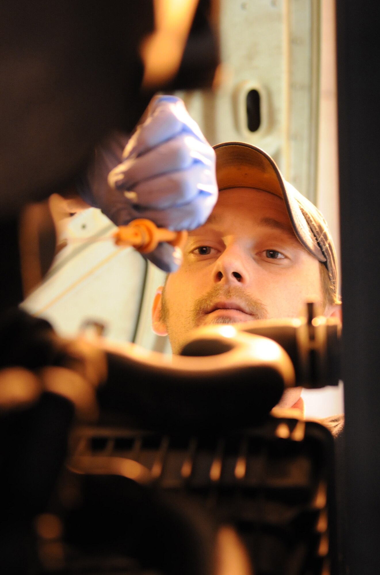 RAF MILDENHALL, England – Brian Muse, volunteer mechanic, pulls out a dip stick to verify proper engine oil levels during an oil change at the Auto Hobby Shop Feb. 24. (U.S. Air Force photo/ Staff Sgt. Jerry Fleshman)