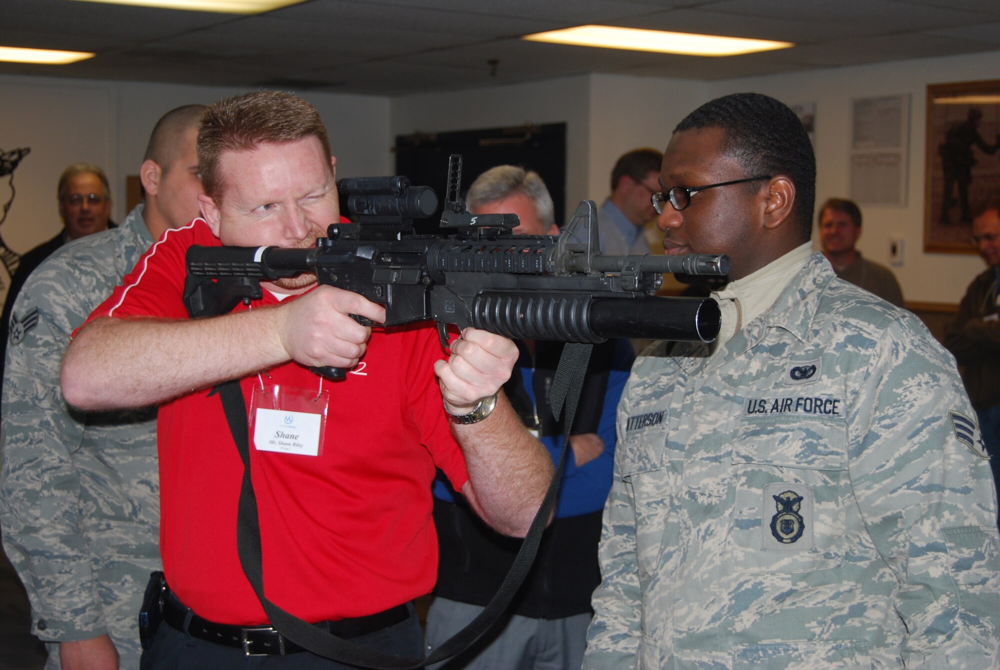 Senior Airman Kevin Patterson, 341st Security Forces Squadrom members, shows Shane Riley, a member of Leadership Montana, the proper technique for holding an M-4 Carbine with M203 grenade launcher attachment during a tour of the base armory Feb. 18.(U.S. Air Force photo/Airman 1st Class Kristina Overton)