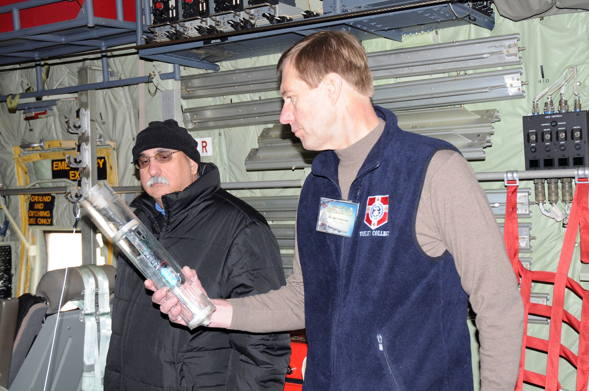 Dr. Bill Johnston (right), Wesley College president, takes a closer look at a weather instrument called a dropsonde, during a Hurricane Hunters tour Feb. 19. Dr. Johnston is one of 19 civic leaders from Dover and surrounding areas, who participated in the 512th Airlift Wing's Civic Leader Tour to Dobbins Air Reserve Base, Ga., and Keesler Air Force Base, Miss. Briefed by 53rd Weather Reconnaissance Squadron members, tour-goers learned how reservists fly into the center of storms or hurricanes and release the dropsonde, which collects and measures various data in direct support of the National Hurricane Center. Also pictured is Tony DePrima, city manager of Dover. (U.S. Air Force photo/Master Sgt. Veronica A. Aceveda)