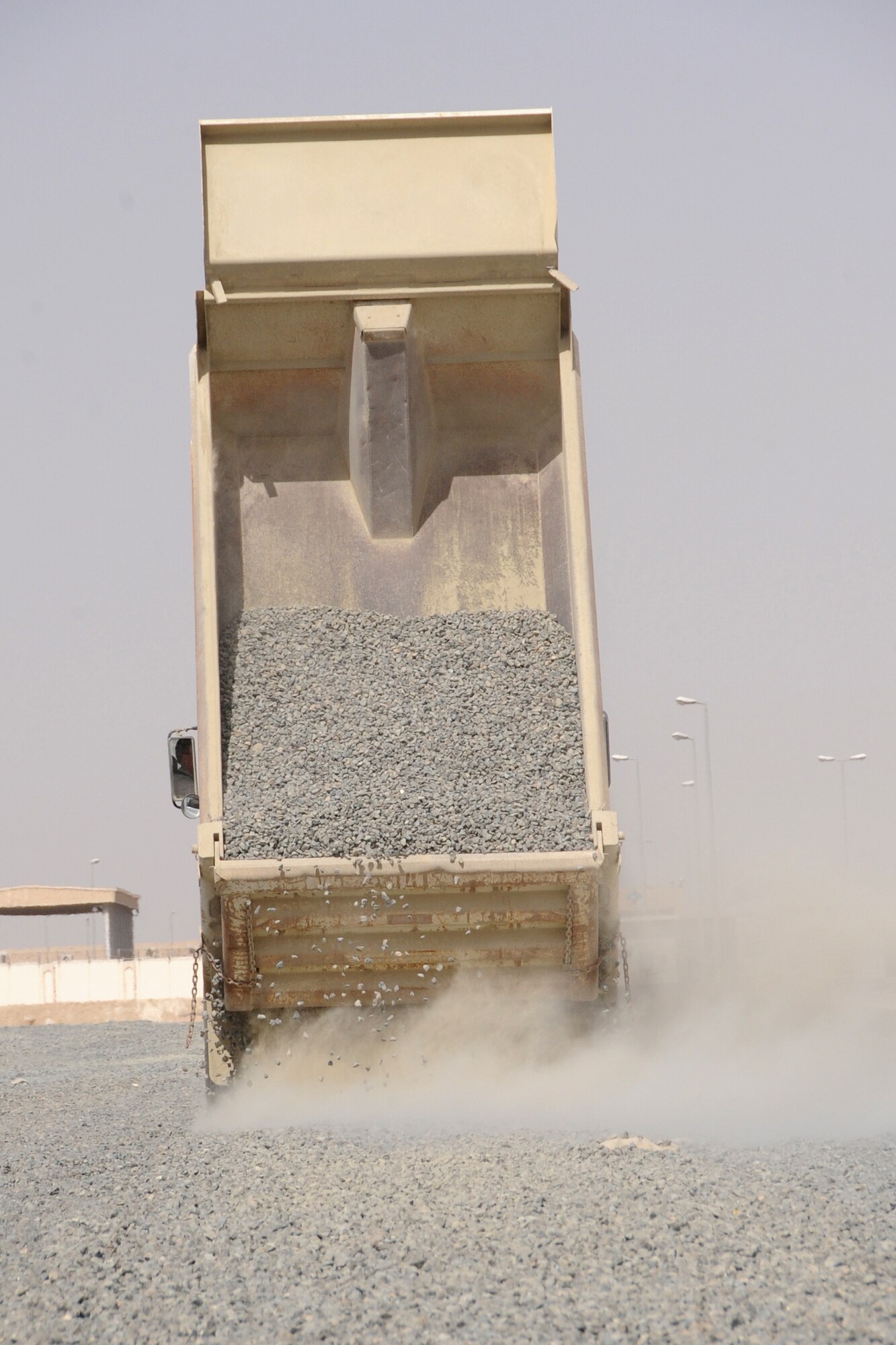 Members of the 380th Expeditionary Civil Engineer Squadron dump a load of rocks from a dump truck at an undisclosed location in Southwest Asia Feb. 24, 2010. (U.S. Air Force Photo/Senior Airman Jenifer H. Calhoun/Released)

