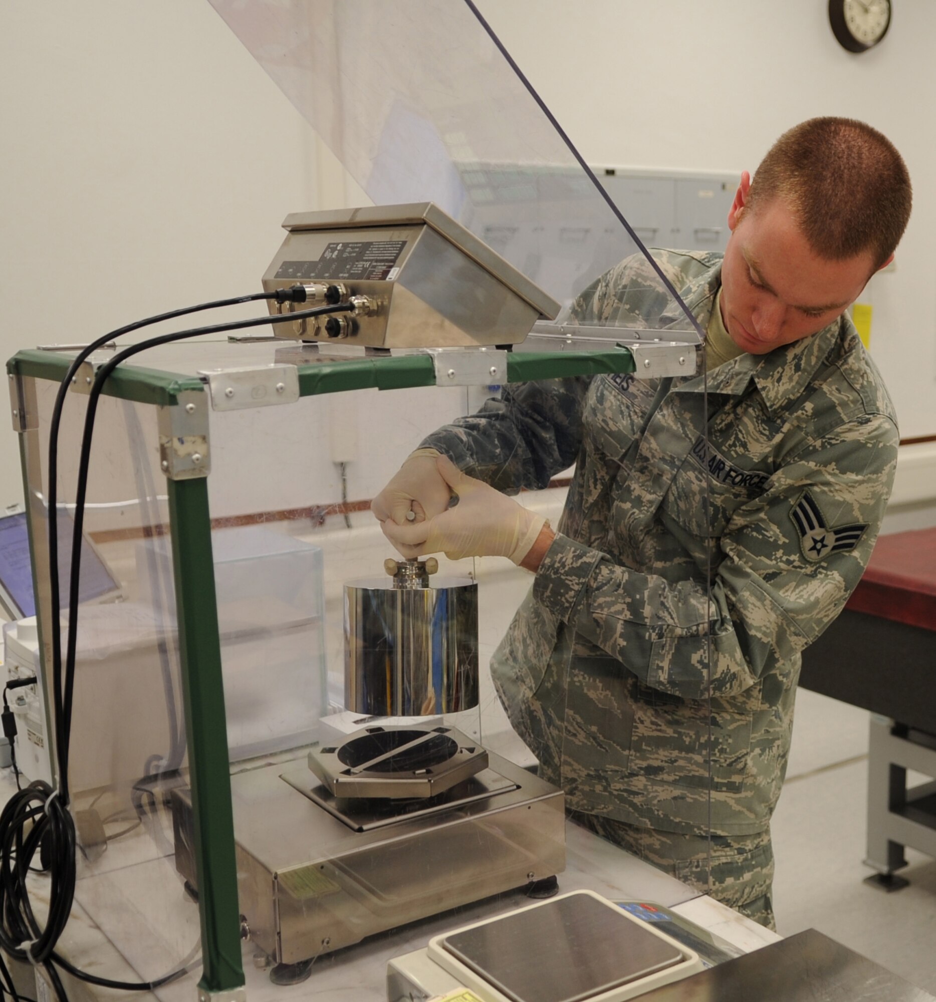 U.S. Air Force Senior Airmen Justin Theis, 86th Maintenance Squadron Test Measurement and Diagnostic flight technician, places precise weight on a scale to calibrate, Ramstein Air Base, Germany, Feb. 23, 2010.  The flight consists of a Scheduling Section, Shipping/Receiving section, Admin Section and the Precision Measurement Equipment Laboratory (PMEL) and services customers throughout United States Air Forces in Europe, United States Central Command, and United States Africa Command. (U.S. Air Force photo by Airman 1st Class Caleb Pierce)