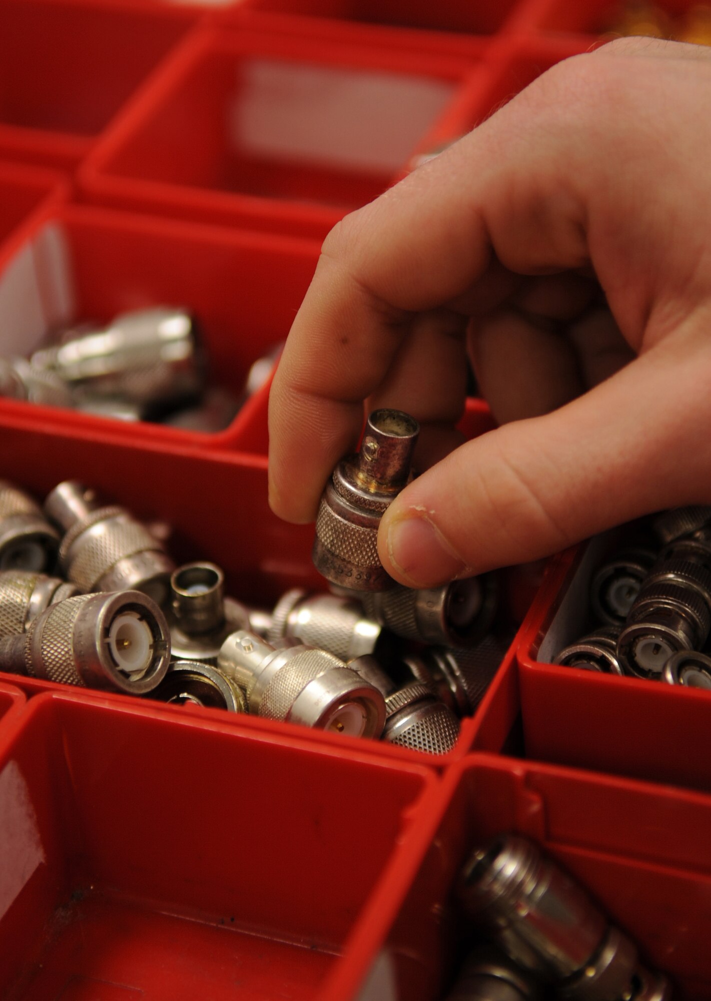 U.S. Air Force Senior Airmen Andrew Gropp, 86th Maintenance Squadron Test Measurement and Diagnostic flight technician, grabs a connector out of a drawer, Ramstein Air Base, Germany, Feb. 23, 2010.  The flight consists of a Scheduling Section, Shipping/Receiving section, Admin Section and the Precision Measurement Equipment Laboratory (PMEL) and services customers throughout United States Air Forces in Europe, United States Central Command, and United States Africa Command. (U.S. Air Force photo by Airman 1st Class Caleb Pierce)