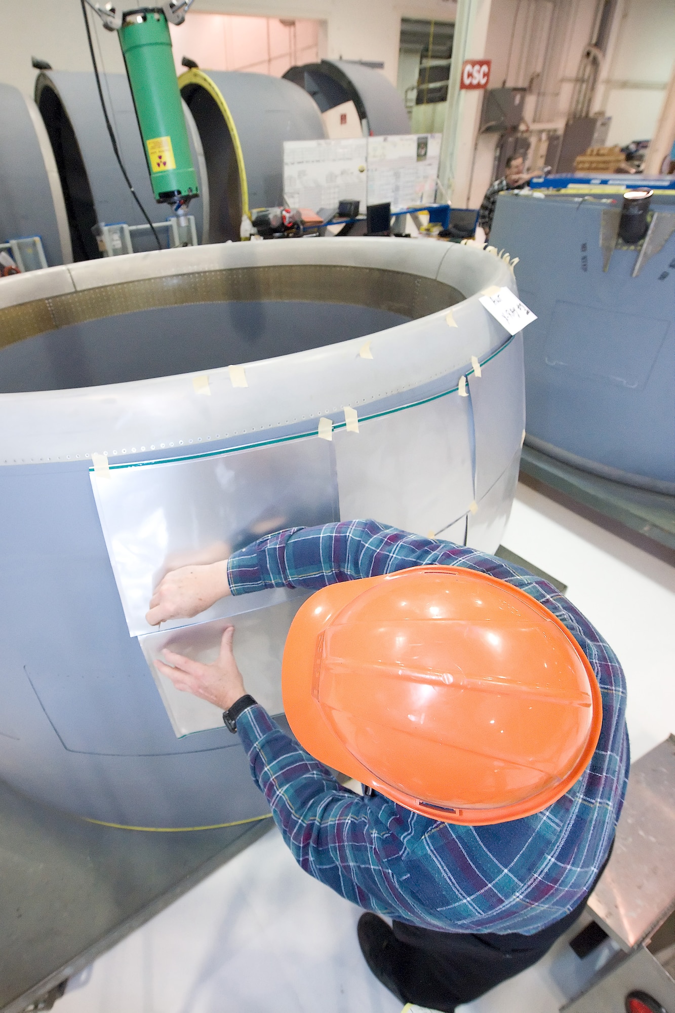 James Thompson, 436th Maintenance Squadron fabrication flight non-destructive inspection technician, attaches x-ray film to the exterior of a C-5 Galaxy Turbo Fan-39 engine inlet. The 436th MXS has been x-raying engine inlets to check for foreign objects stuck inside, which could cause damage to the engine. The x-ray, each marked by its location on the inlet, will show if there are any pieces of potentially damaging metal inside the inlet. (U.S.Air Force photo/Brianne Zimny)
