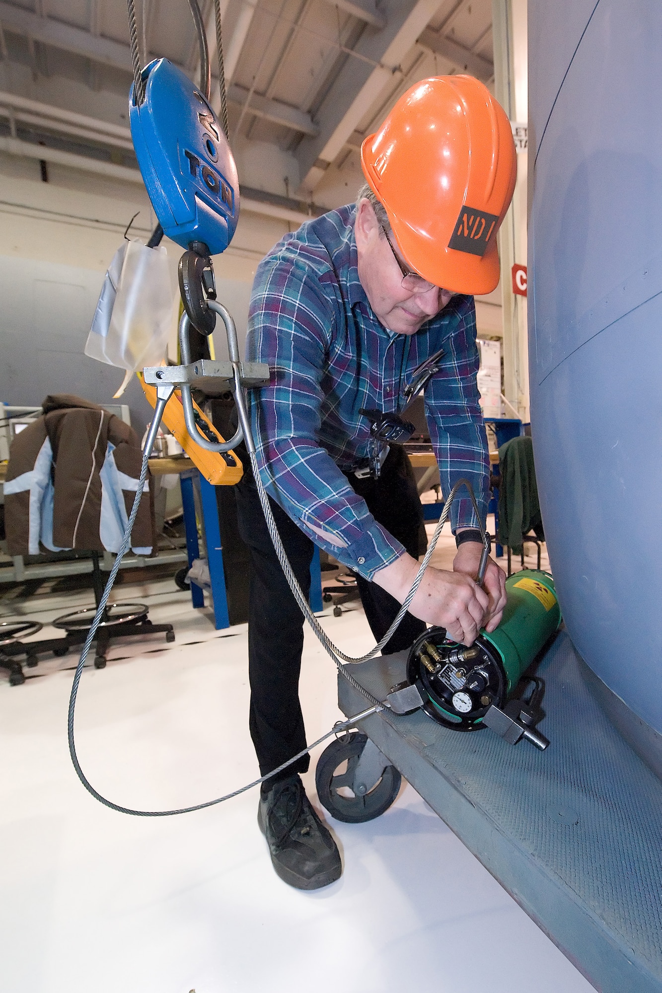 James Thompson, 436th Maintenance Squadron fabrication flight non-destructive inspection technician, attaches the x-ray machine to chords so that it can be hoisted up and hung in the center of the engine inlet for x-ray photos to be taken. The 436th MXS has been x-raying the C-5 Galaxy Turbo Fan-39 engine inlets to check for foreign objects caught between the metal layers. The x-ray will show if there are any pieces of potentially damaging metal inside the inlet, and members of the propulsion flight can then remove the foreign objects, to prevent damage. (U.S. Air Force photo/Brianne Zimny)