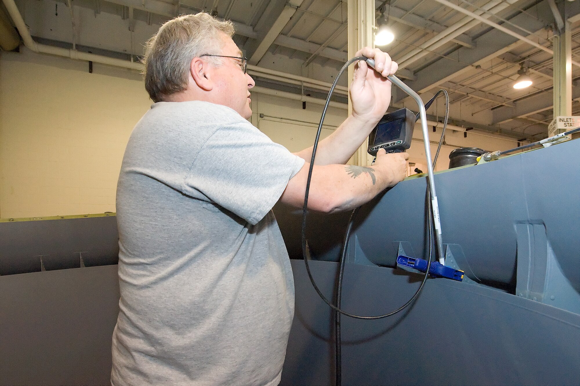 Ricky Anthony, 436th Maintenance Squadron propulsion flight lead inspector, stands inside a C-5 Galaxy Turbo Fan-39 engine inlet, while watching a screen as he moves the boroscope in search of any foreign objects that may have gotten stuck inside the inlet. The 436th MXS is working to ensure that there are no foreign objects remaining inside the inlet by using a combination of x-raying and boroscope searches. (U.S. Air Force photo/Brianne Zimny)