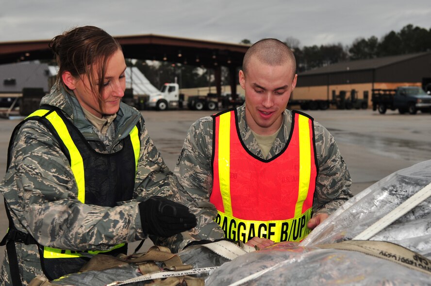 SEYMOUR JOHNSON AIR FORCE BASE, S.C. -- Senior Airman Brittney Cummings, 4th Logistics Readiness Squadron air transportation journeyman, shows Airman 1st Class Colby Webb, 4th Civil Engineer Squadron engineering apprentice, how to loosen and tighten a ratchet strap during a Phase I exercise on Seymour Johnson Air Force Base, N.C., Feb. 22, 2010. The ratchet straps secure the personal bags of deployers for transportation. Airman Cummings hails from Katy, Texas, and Airman Webb is from Ashville, N.C. (U.S. Air Force photo/Senior Airman Rae Perry)