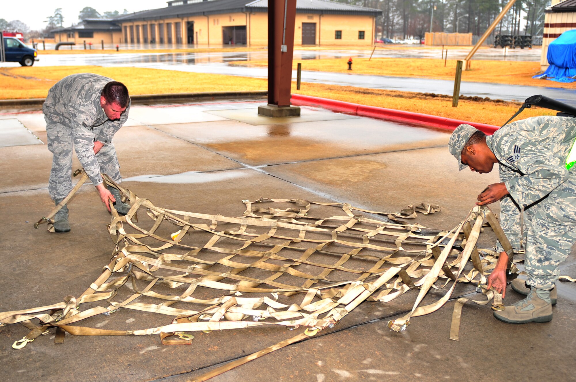 Airmen from the 4th Logistics Readiness Squadron untangle cargo netting used on palletized equipment during a Phase I exercise on Seymour Johnson Air Force Base, N.C., Feb. 22, 2010. The Phase I exercise tests the ability of the wing to deploy personnel and cargo at a moment's notice. (U.S. Air Force photo/Senior Airman Rae Perry) 